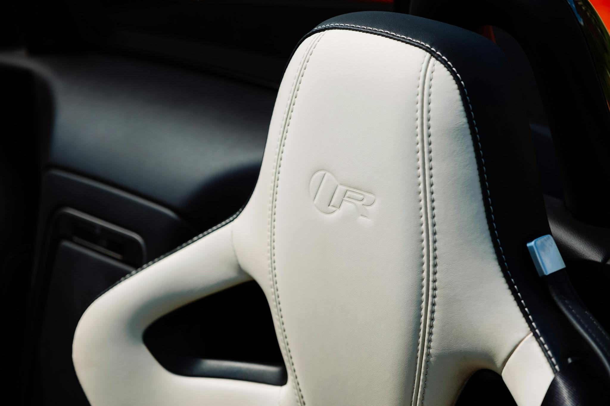 Close-up of a luxury car's white leather seat showcasing high-quality craftsmanship and design.