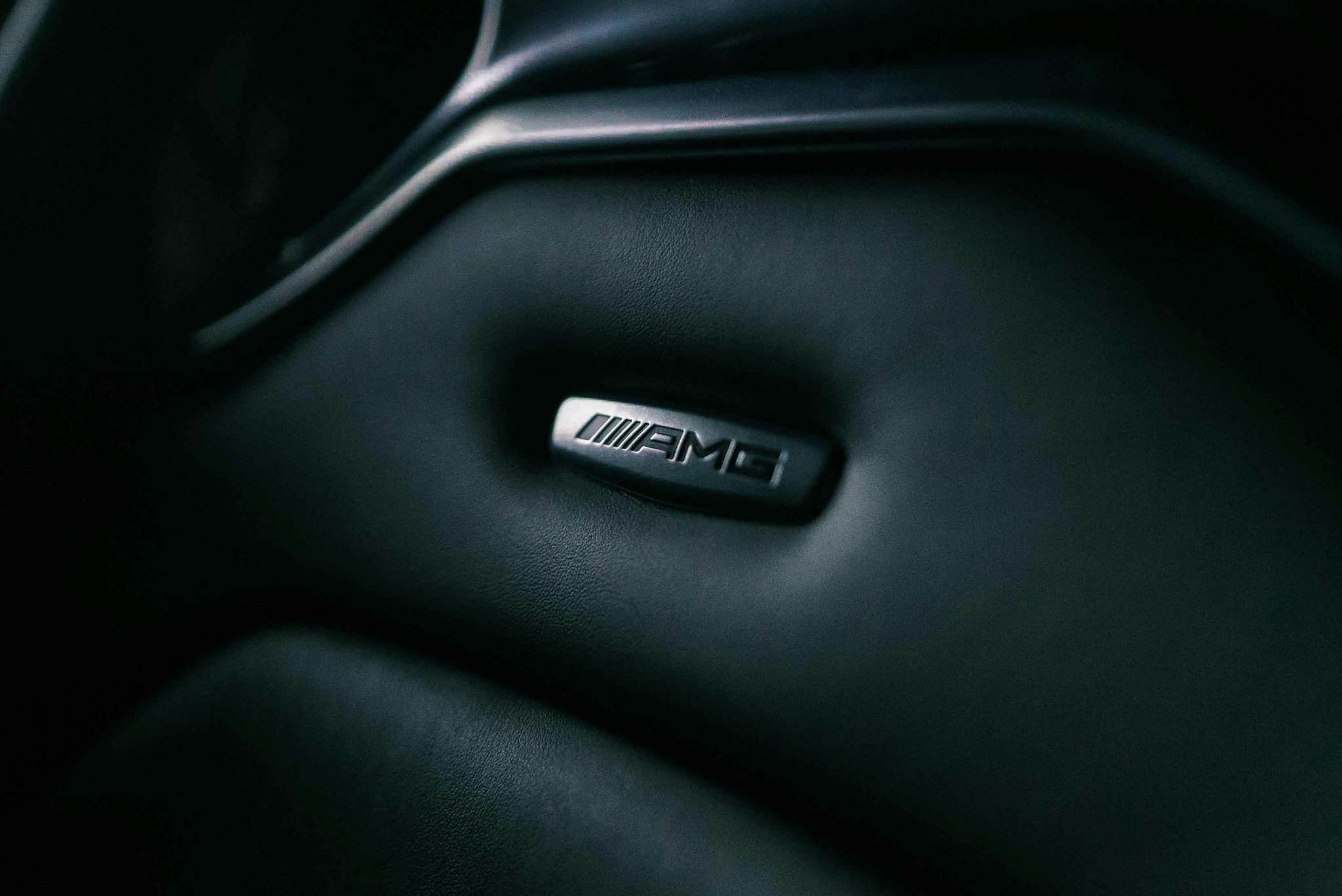 Detail shot of an AMG logo on luxury car interior, representing elegance and premium design.
