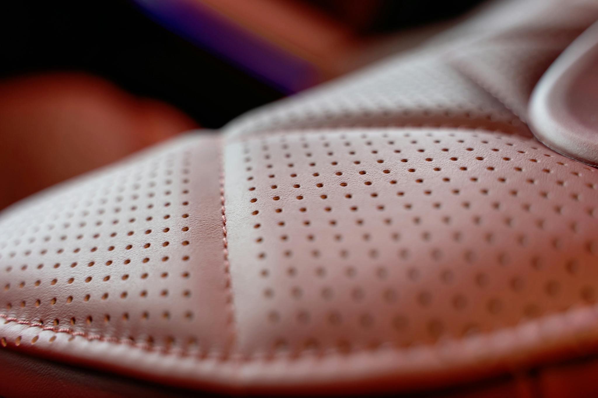 Detailed close-up of premium brown perforated leather car seat in Dubai.
