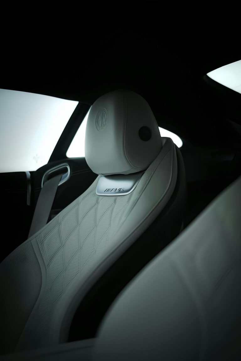 Close-up of luxury car's white leather seat showcasing premium design and detail.