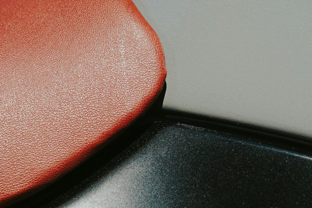 Detailed close-up showing the texture of a red leather seat, emphasizing the rich material.